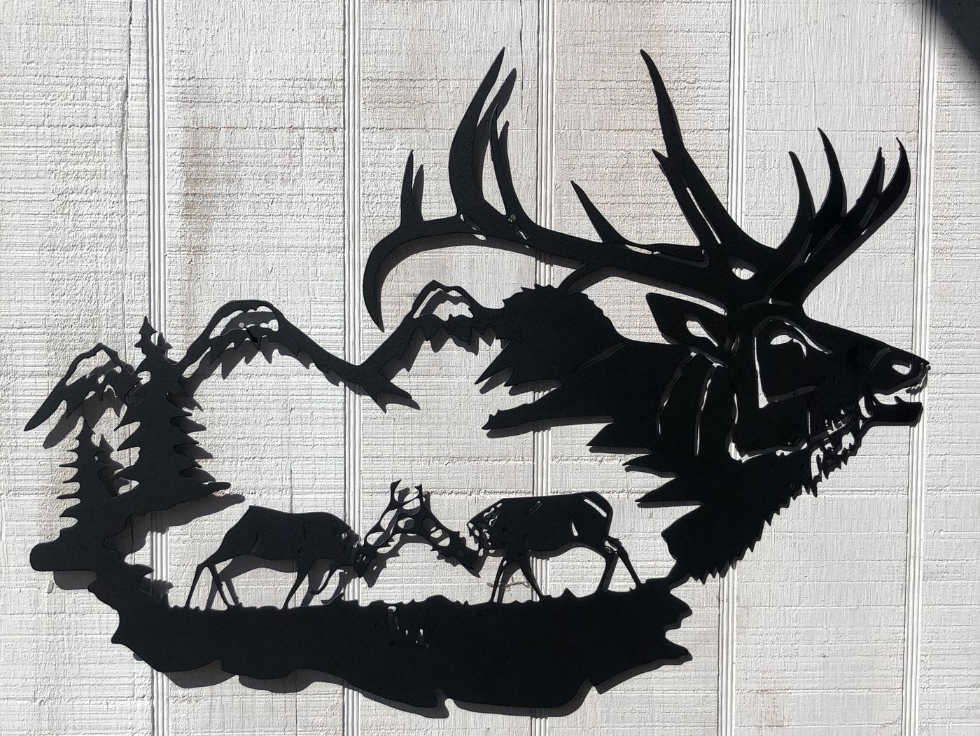 Black steel elk and mountain wall art on white siding